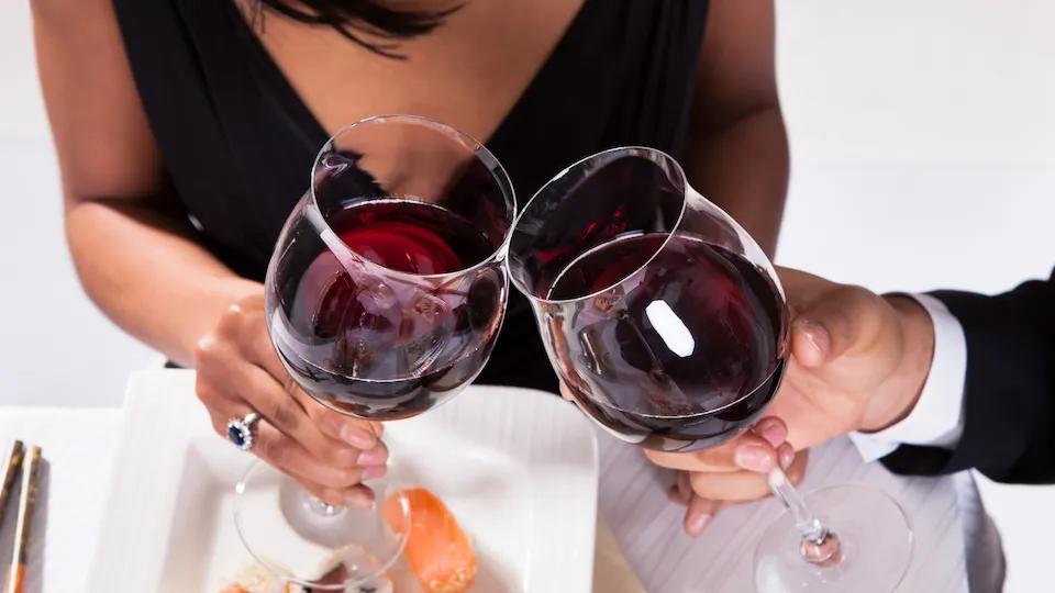 Una coppia beve un bicchiere di vino rosso