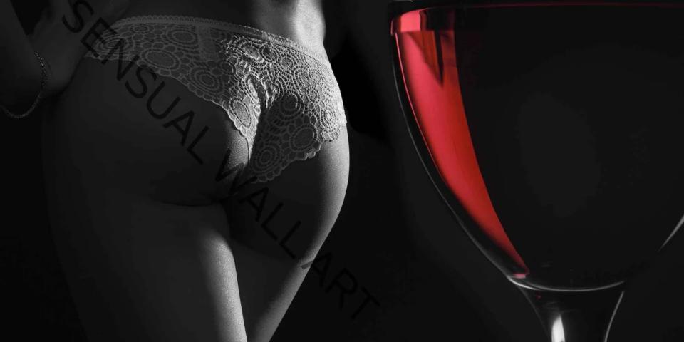 Un culo sexy di una donna con accanto un bicchiere di vino